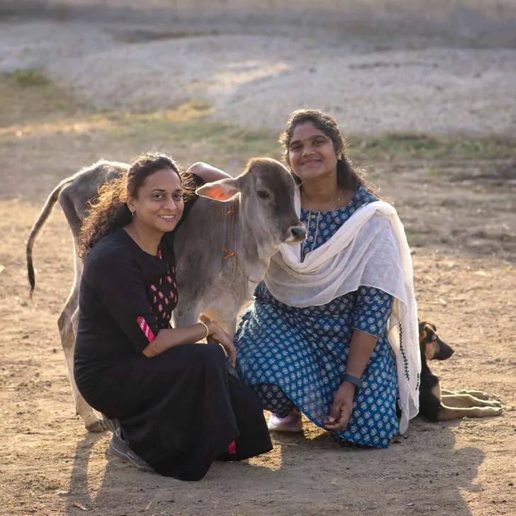 SAFI staff members smiling with a rescued calf at the shelter