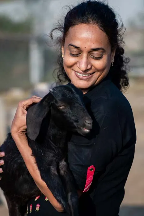 A SAFI volunteer cuddling a rescued baby goat