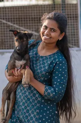 A SAFI team member holding a rescued puppy