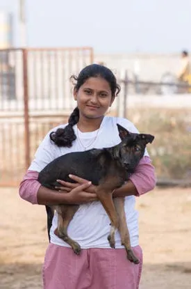 A SAFI volunteer holding a rescued puppy